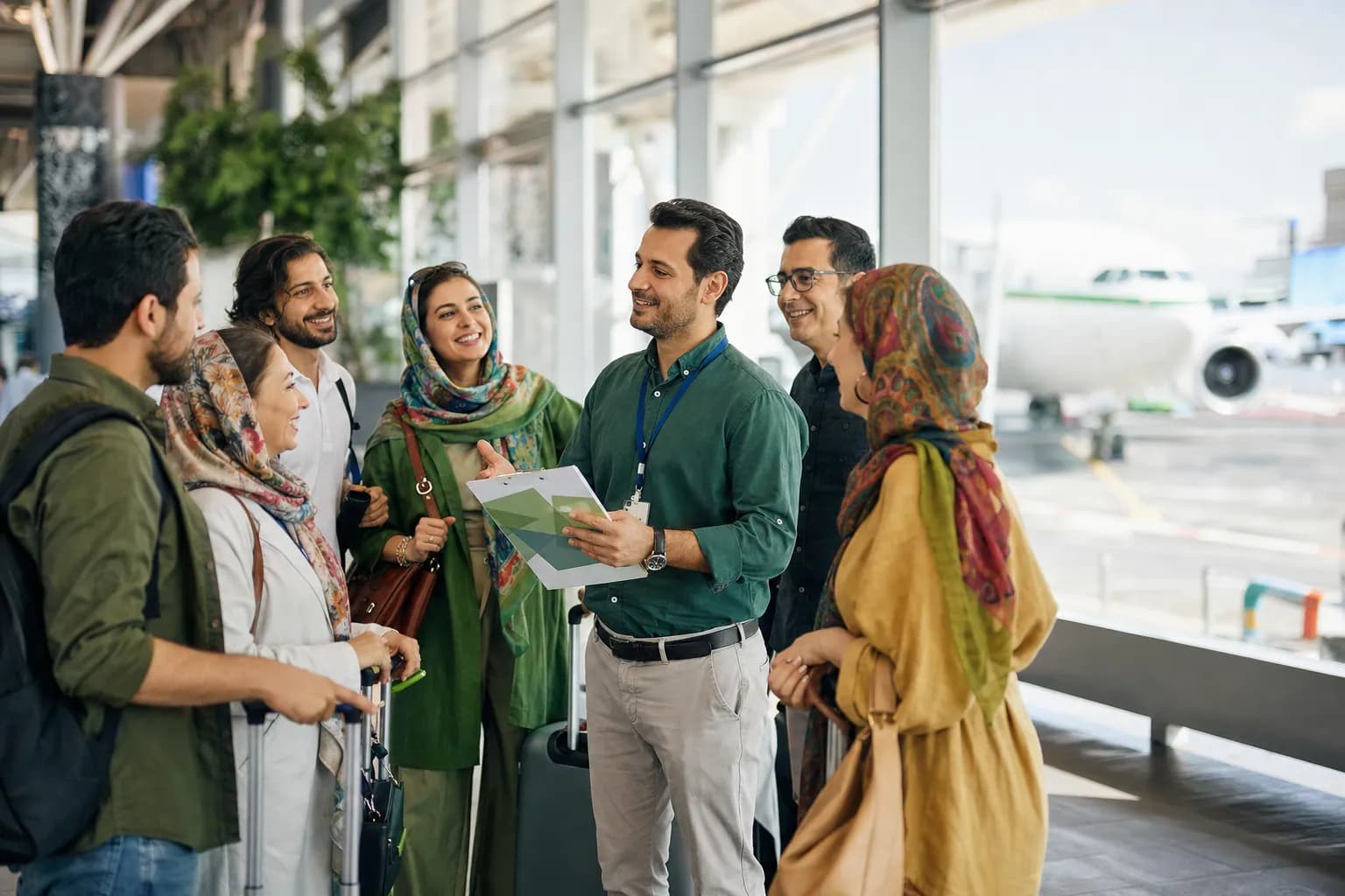 برگزارکنندهی سفر گروهی با مسافرانش در فرودگاه